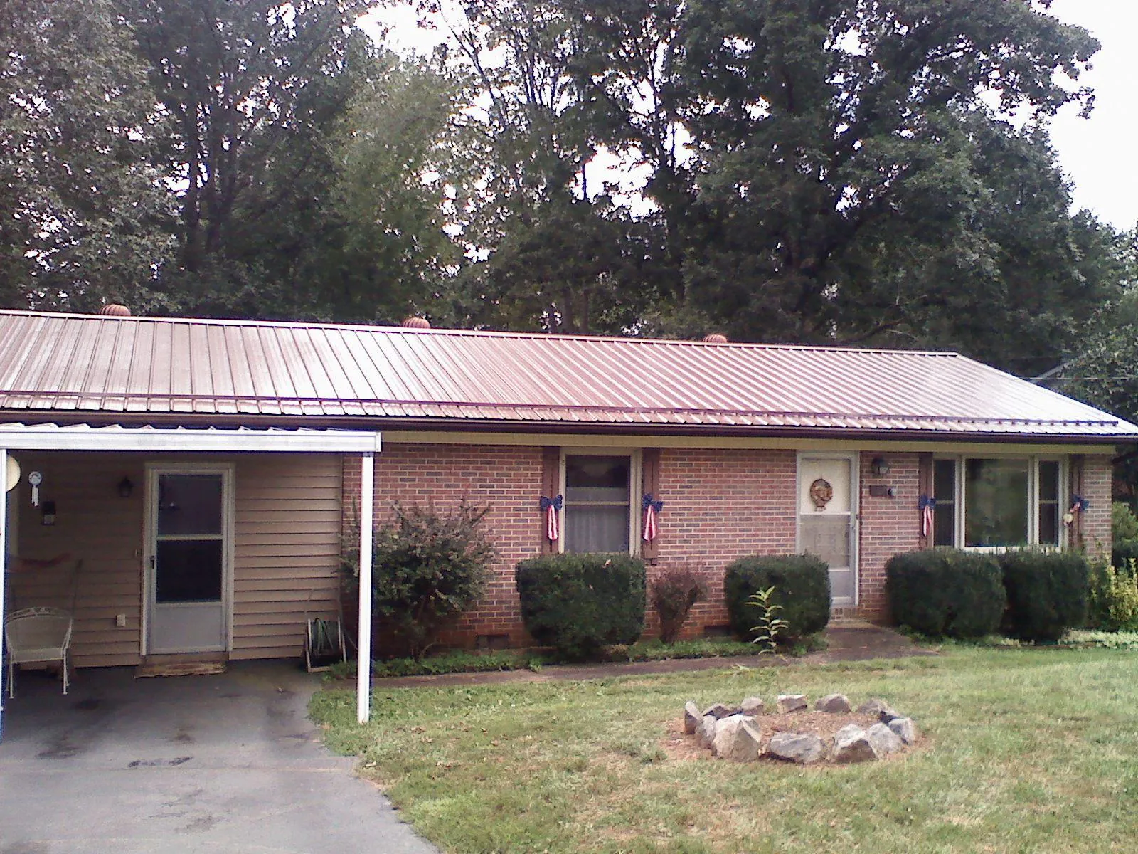 Bronze metal roof and carport on a brick ranch home — Roof Repair work by our crew in Lake Worth